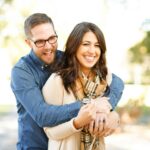 A happy couple enjoying an outdoor engagement photoshoot with laughter and love.