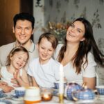 Cheerful family of four enjoying a warm and cozy teatime at home, surrounded by love and laughter.