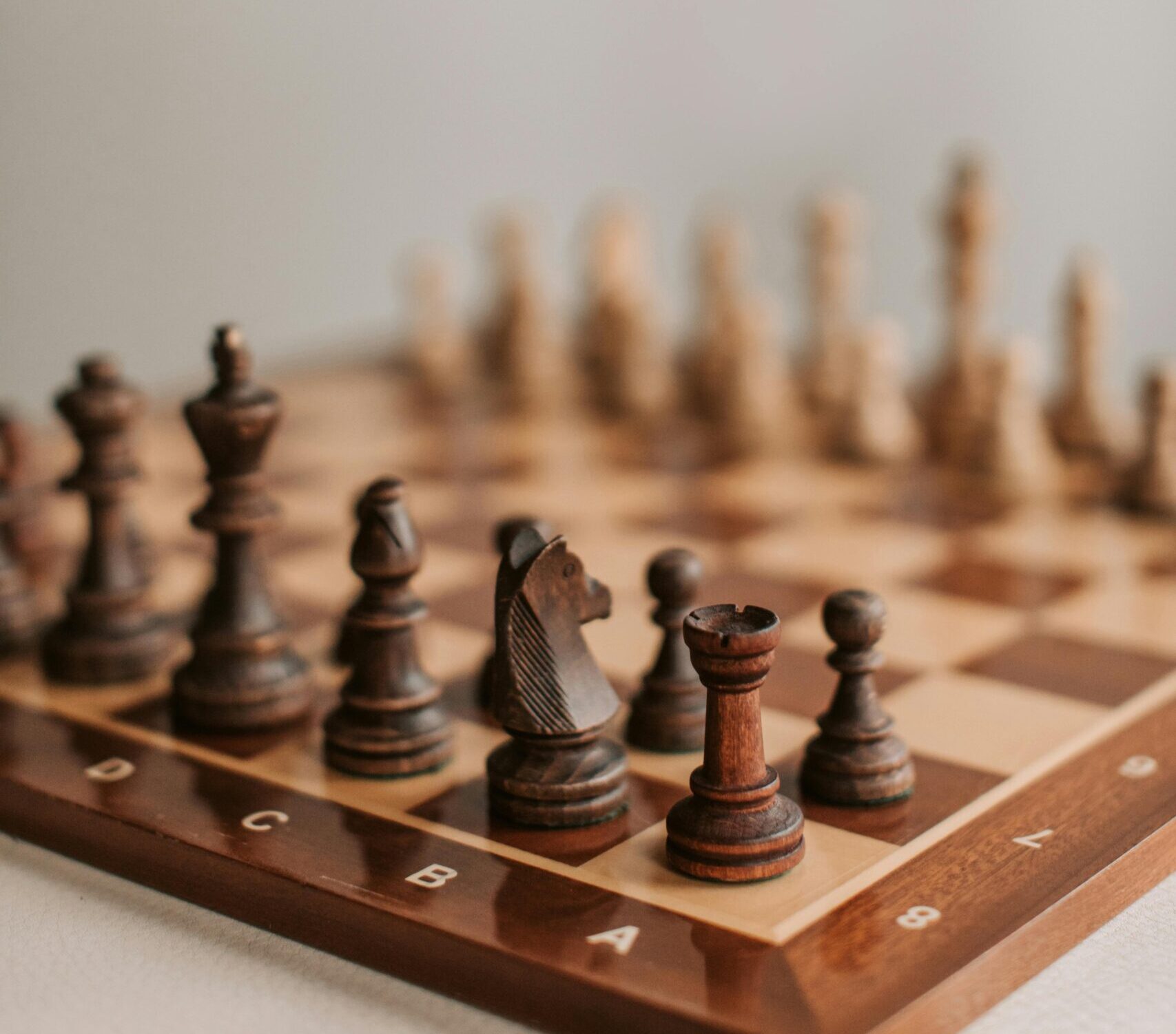 Close-up of arranged chess pieces on a chessboard highlighting strategy and focus.