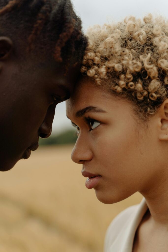 Close-up portrait of a couple sharing an intimate moment outdoors.