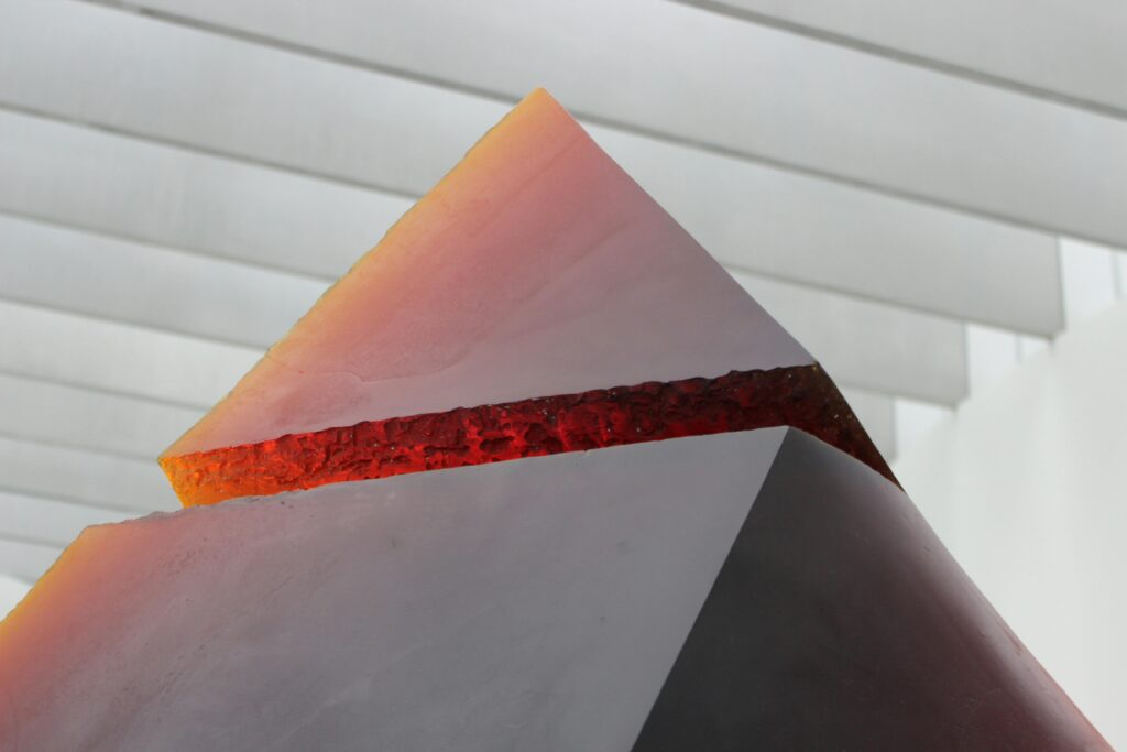 A striking abstract pyramid sculpture with bold colors and unique design indoors.