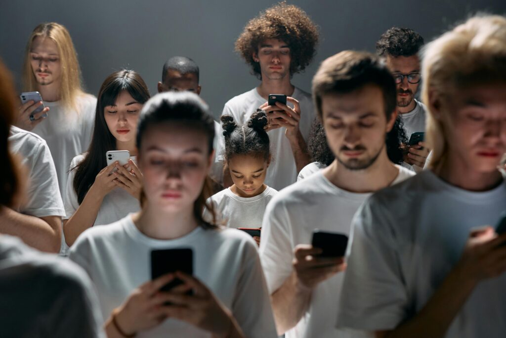 A diverse group of people engrossed in their smartphones, highlighting modern social connectivity.